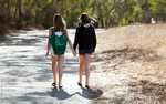 Best Friends Walking Down A Path Holding Hands by Carolyn La